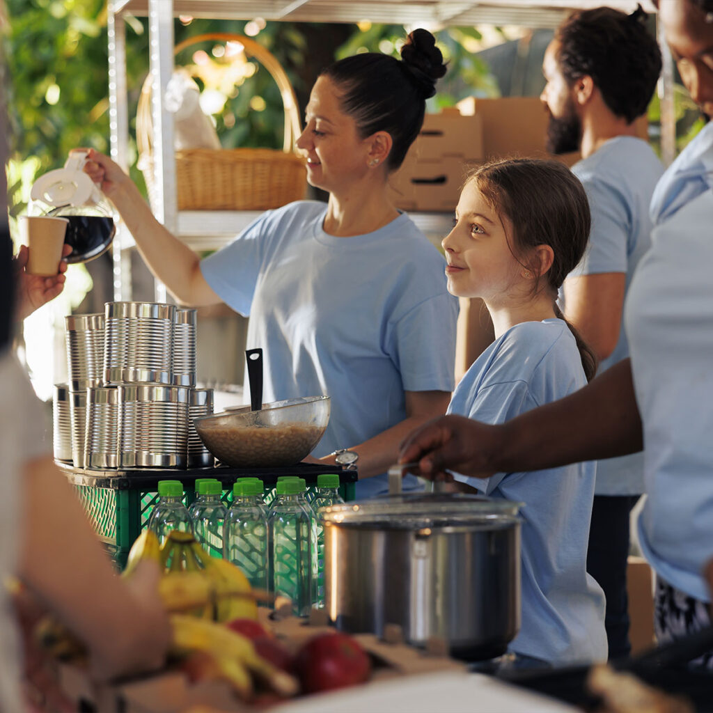 Des bénévoles se trouvent à leur kiosque distribuant de la nourriture.